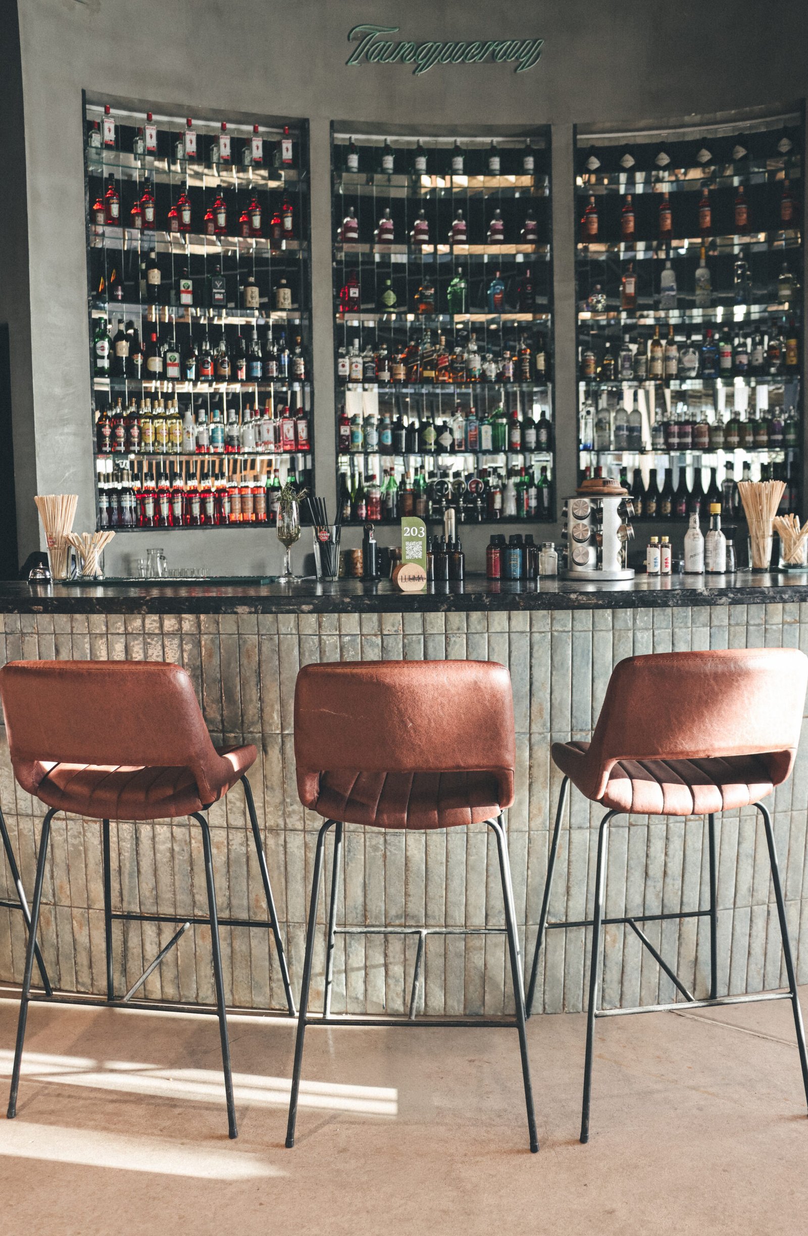 Banquetas altas en barra de cocina con mesada de granito negro Boreal leather