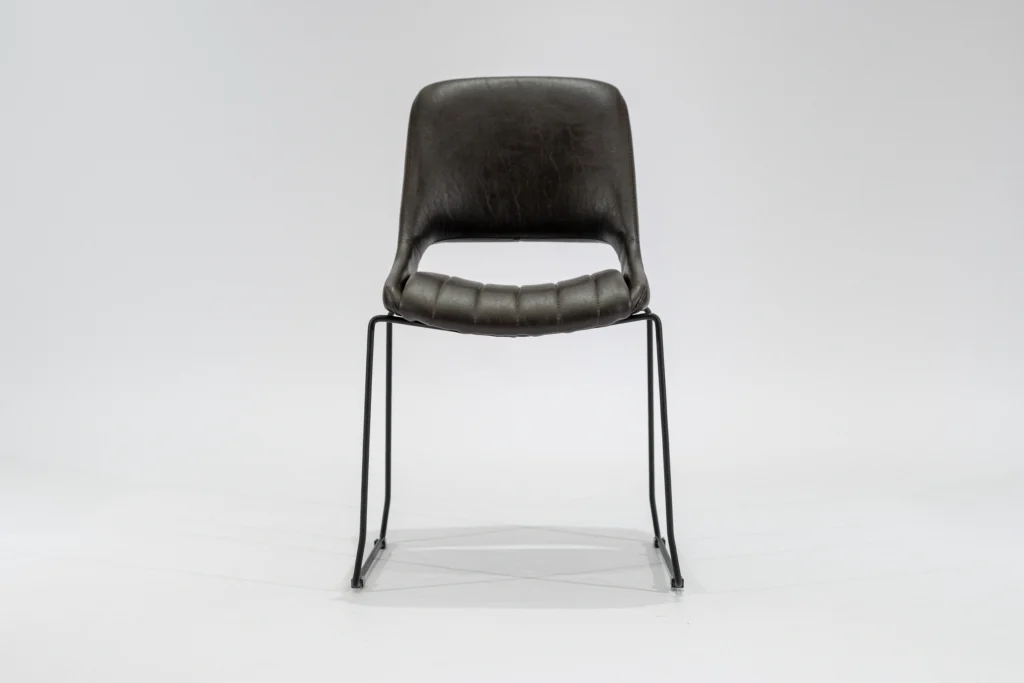 Silla de comedor tapizada en ecocuero color chocolate con estructura de hierro negro microtexturado vista frontal.