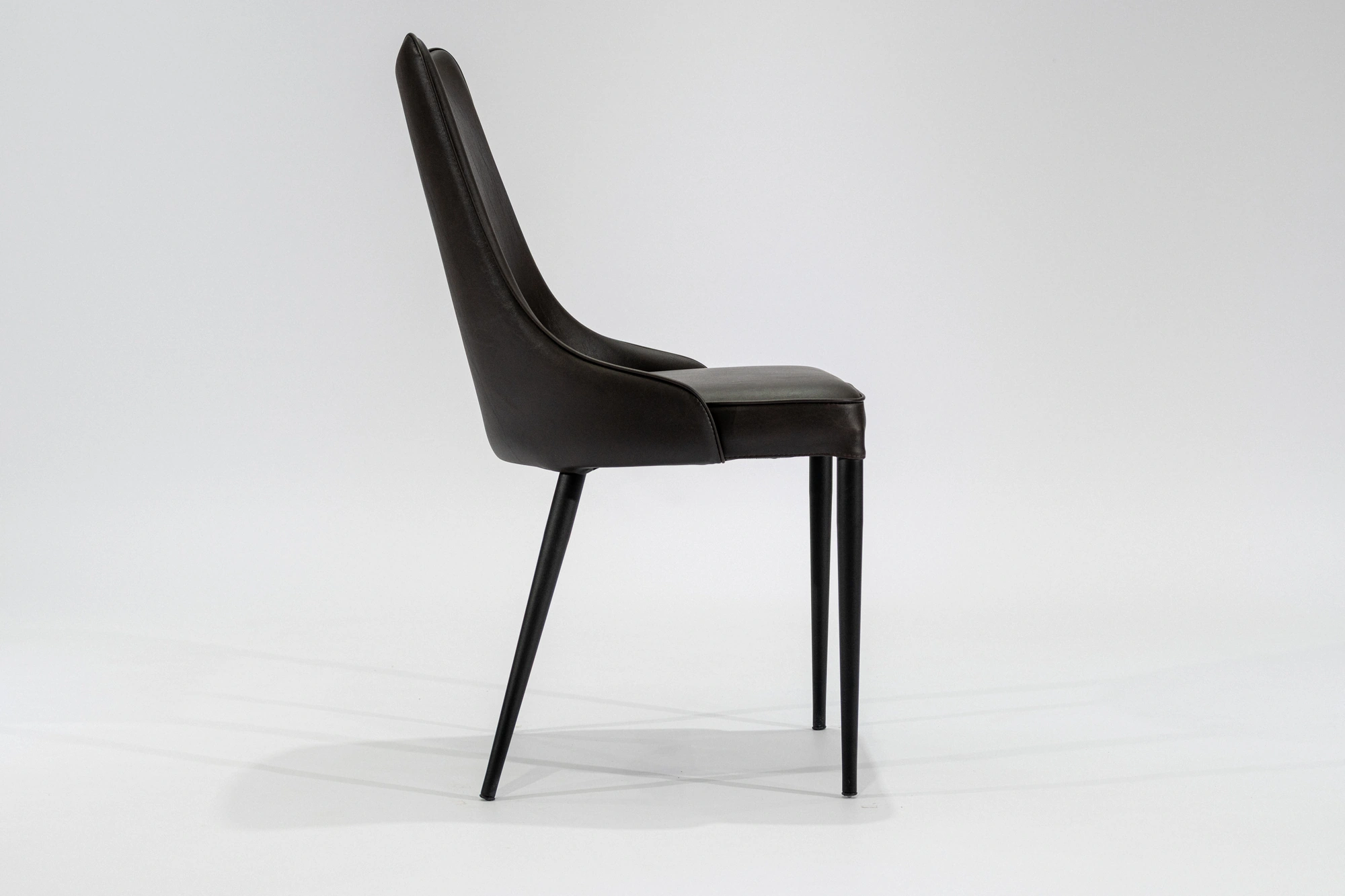 silla-comedor-tapizada-simil-cuero-chocolate-hierro-negro-lateral... Silla de comedor tapizada en ecocuero color chocolate con estructura de hierro negro microtexturado vista lateral
