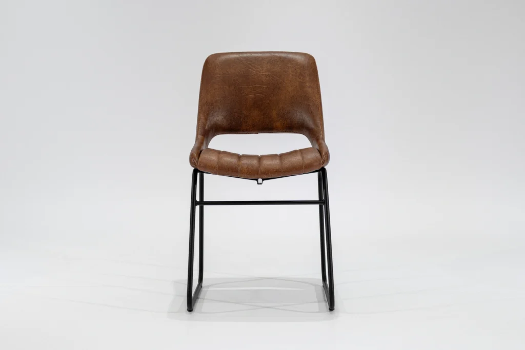 Silla de comedor tapizada en ecocuero color habano con estructura de hierro negro microtexturado vista frontal