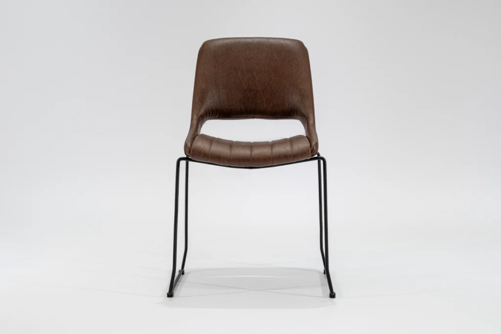 Silla de comedor tapizada en ecocuero color habano con estructura de hierro negro microtexturado vista frontal.