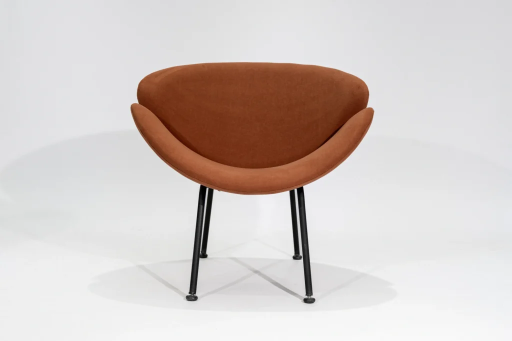 Silla poltrona tapizada en tela pana color terracota con estructura de hierro negro microtexturado vista frontal