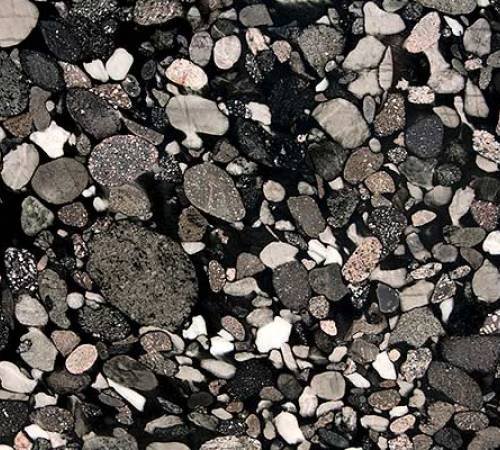 Granito Nero Marinace de piedra natural con cantos rodados negros, grises y blancos, ideal para mesadas, revestimientos y proyectos de arquitectura e interiorismo.