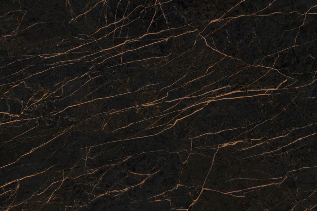 Neolith Mamba, piedra sinterizada de fondo negro profundo con finas vetas doradas y cobrizas, ideal para mesadas y revestimientos.